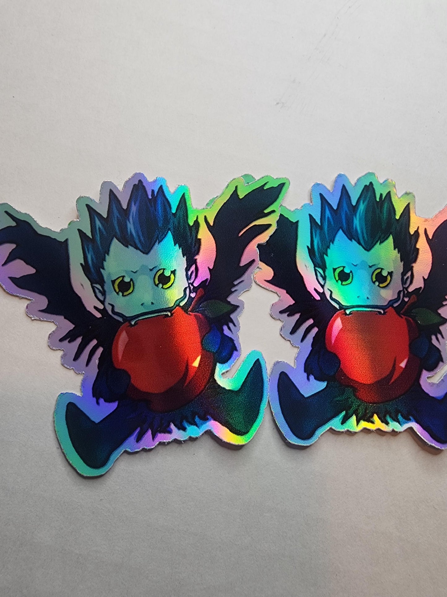 Chibi Ryuk Holographic Sticker - Mischievous Shinigami with Apple - Collectible Anime Sticker for Fans - Laptop & Journal Decor