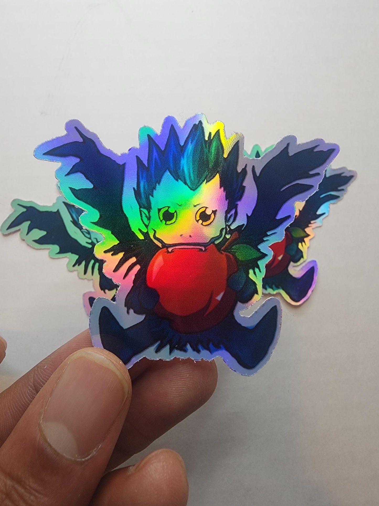 Chibi Ryuk Holographic Sticker - Mischievous Shinigami with Apple - Collectible Anime Sticker for Fans - Laptop & Journal Decor